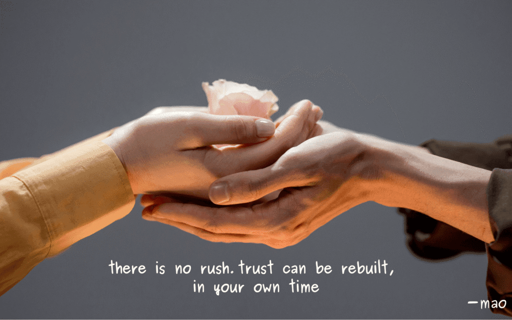 image depicting trust, with hands gently holding a flower with other hands supporting underneath. quote "there is no rush. trust can be rebuilt, in your own time" - mao