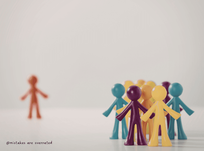group of toy people standing together and one toy person standing further away