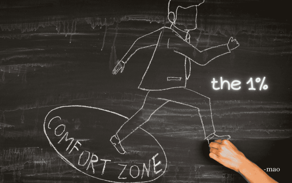 a chalk drawing of a circle saying "comfort zone" and a person stepping out if it, with poem title "the 1%" in neon writing