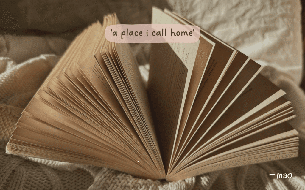 book open on bed with 'a place i call home' poem title written.